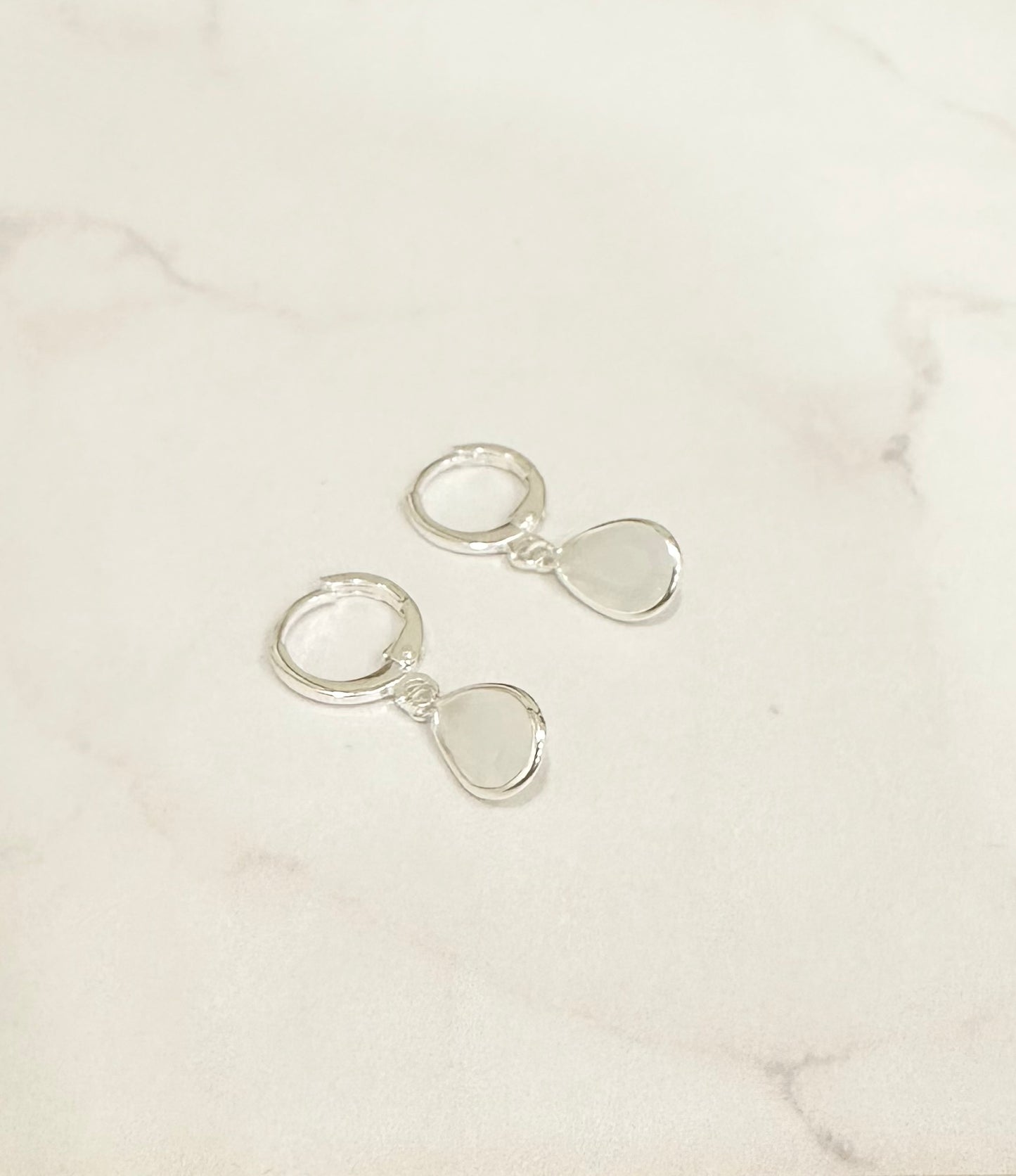 Argollas plateadas con cristales blancos y rosados